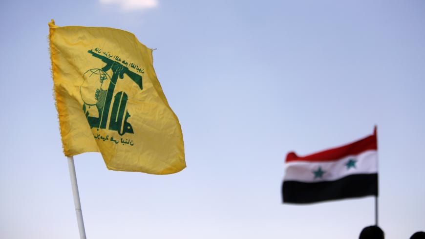 Hezbollah and Syrian flags are seen fluttering in Fleita, Syria August 2, 2017. REUTERS/ Omar Sanadiki - RC15E3E7FA20