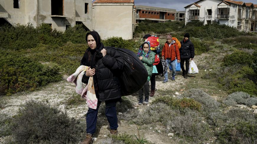 Afghan refugees walk through a beach where they will wait to board a dinghy sailing off for the Greek island of Chios, while they try to travel from the western Turkish coastal town of Cesme, in Izmir province, Turkey, March 6, 2016. REUTERS/Umit Bektas      TPX IMAGES OF THE DAY      - GF10000335606
