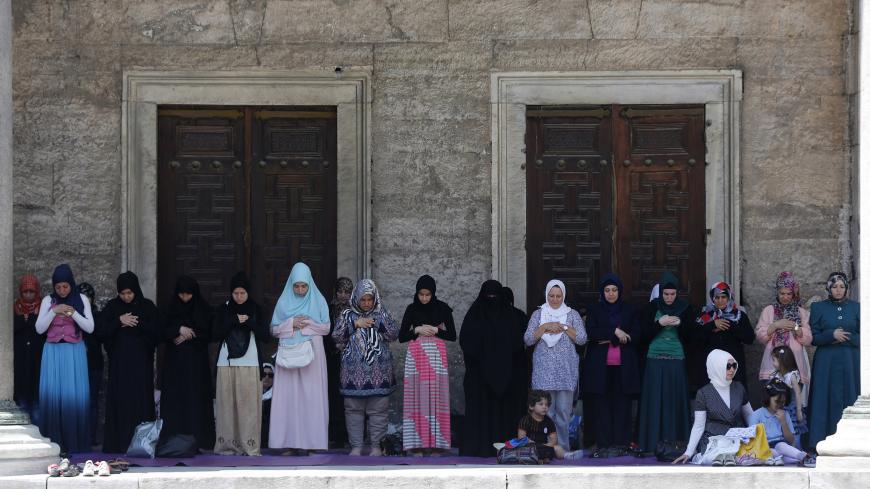 Women attend Friday prayers during the Muslim holy month of Ramadan at the courtyard of Sultanahmet mosque, also known as the Blue Mosque, in Istanbul July 12, 2013. REUTERS/Murad Sezer (TURKEY - Tags: RELIGION) - GM1E97C1OJG01