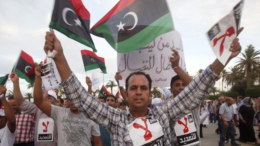 Demonstrators protest against the General National Congress (GNC) at the Martyrs' Square in Tripoli, November 9, 2013. According to the demonstrators, they were unhappy that the GNC had done little to help them and were demanding that fresh elections be held to choose another body to govern the country. The words on the protesters' chests read, "No to extension", a reference to the protesters' objections against the GNC from extending their governing term once their mandate was over. REUTERS/Ismail Zitouny 