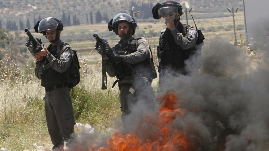 Israeli border policemen take up position during clashes with Palestinian protesters following a protest marking Nakba Day near Israel's Hawra checkpoint near the West Bank city of Nablus May 16, 2015. Palestinians marked "Nakba" (Catastrophe) on May 15 to commemorate the expulsion or fleeing of some 700,000 Palestinians from their homes in the war that led to the founding of Israel in 1948. REUTERS/Abed Omar Qusini  - GF10000096946