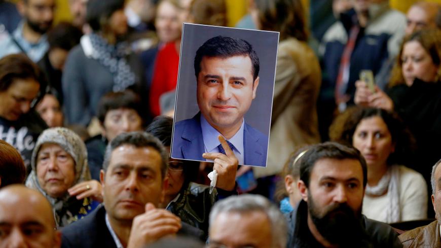A supporter holds a portrait of Selahattin Demirtas, detained leader of Turkey's pro-Kurdish opposition Peoples' Democratic Party (HDP) at a meeting at the Turkish parliament in Ankara, Turkey, November 8, 2016, in the absence of Demirtas and other HDP lawmakers who were jailed after refusing to give testimony in a probe linked to "terrorist propaganda".  REUTERS/Umit Bektas - D1BEULQHGVAA