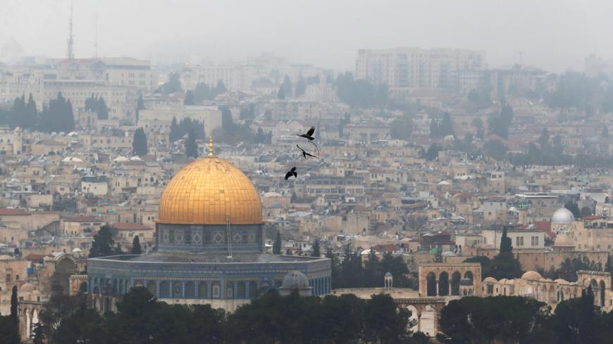 Birds fly on a foggy day near the Dome of the Rock, located in Jerusalem's Old City on the compound known to Muslims as Noble Sanctuary and to Jews as Temple Mount, Jerusalem, January 2, 2018. REUTERS/Ammar Awad - RC1FAC4E2C00