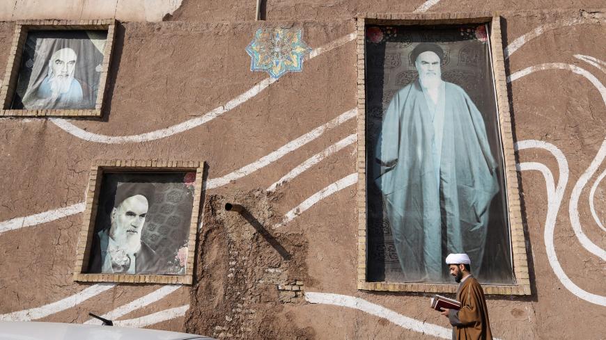 A Muslim Shiite cleric walks past the house of the late founder of the Islamic Republic, Ayatollah Ruhollah Khomeini, in the holy city of Qom, 130 kilometres south of Tehran on January 15, 2019. - In the religious capital of Iran, the Islamic revolution still holds a powerful sway even as once-unthinkable signs of modernity creep into the city of Qom to challenge the faithful. Qom, a couple of hours drive south of Tehran, is one of Shiite Islam's holiest sites, home to dozens of seminaries and many of its m