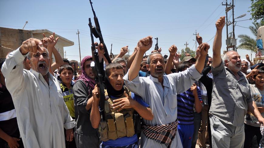 Iraqi Turkmen shout slogans holding weapons as they gather to express their willingness to join Iraqi security forces in the fight against Jihadist militants who have taken over several northern Iraqi cities on June 23, 2014, in the Iraqi village of Taza Khormato, 20 kilometers south of the city of Kirkuk. Sunni Arab militants hold a string of towns and surrounding areas west and south of the the ethnically mixed oil city of Kirkuk.  AFP PHOTO / MARWAN IBRAHIM        (Photo credit should read MARWAN IBRAHIM