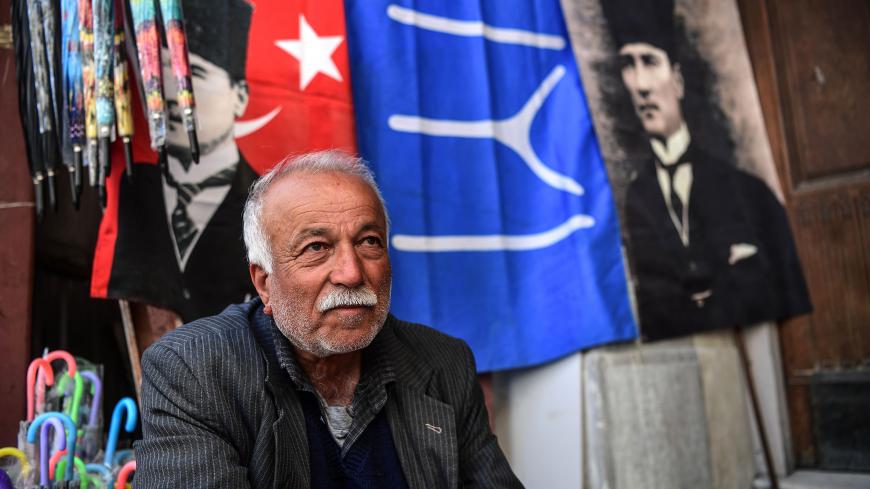A man sits in front of poster flags of Mustafa Kemal Ataturk, founder of modern Turkey, near spice bazaar at Eminonu district on April 19, 2018 in Istanbul. - President Recep Tayyip Erdogan on April 18, 2018 called snap elections in Turkey for June 24, bringing the polls forward by over a year-and-a-half after a call from his main nationalist ally. (Photo by OZAN KOSE / AFP)        (Photo credit should read OZAN KOSE/AFP/Getty Images)