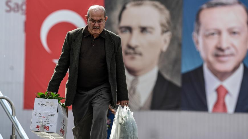A man walks in front of the portraits of Turkish President Recep Tayyip Erdogan (R) and founder of modern Turkey Mustafa Kemal Ataturk (L), on May 11, 2018 at Emininonu district in Istanbul. - President Recep Tayyip Erdogan called snap elections in Turkey for June 24, bringing the polls forward by over a year and a half after a call from his main nationalist ally on April 18, 2018. (Photo by OZAN KOSE / AFP)        (Photo credit should read OZAN KOSE/AFP/Getty Images)