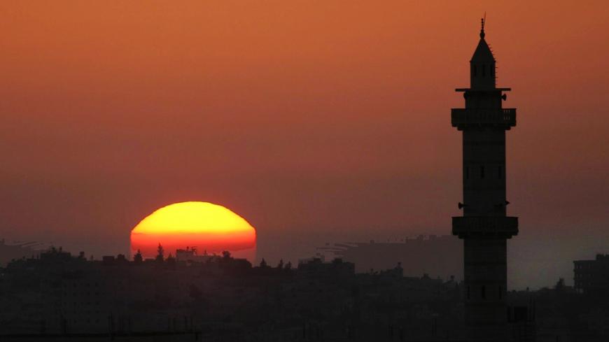 The sun sets behind the Alomary mosque in the West Bank city of Ramallah October 23, 2004. Hamas gunmen killed a young Palestinian they accused of helping Israel assassinate Hamas leader Sheikh Ahmed Yassin and other militants, calling it a warning to others not to collaborate with Israel. REUTERS/Loay Abu Haykel. NO RIGHTS CLEARANCES OR PERMISSIONS ARE REQUIRED FOR THIS IMAGE.  GOT/WS - RP5DRHZZROAB