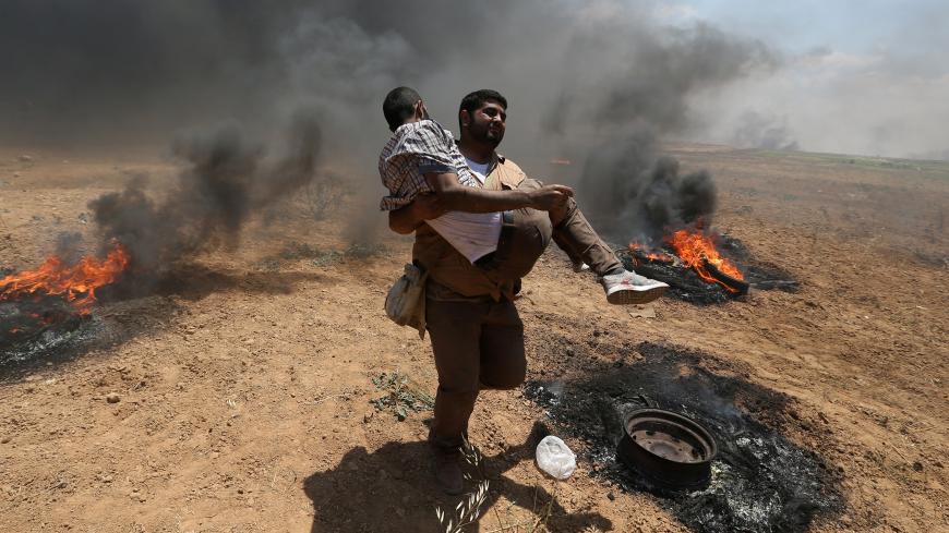A wounded Palestinian demonstrator is evacuated during a protest against U.S. embassy move to Jerusalem and ahead of the 70th anniversary of Nakba, at the Israel-Gaza border in the southern Gaza Strip May 14, 2018. REUTERS/Ibraheem Abu Mustafa - RC1119F74020