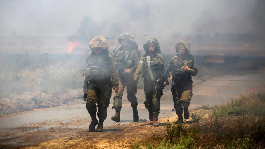 Israeli soldiers patrol near a burning field on the Israeli side of the border between Israel and Gaza, May 14, 2018. REUTERS/Amir Cohen     TPX IMAGES OF THE DAY - RC1FB2222060