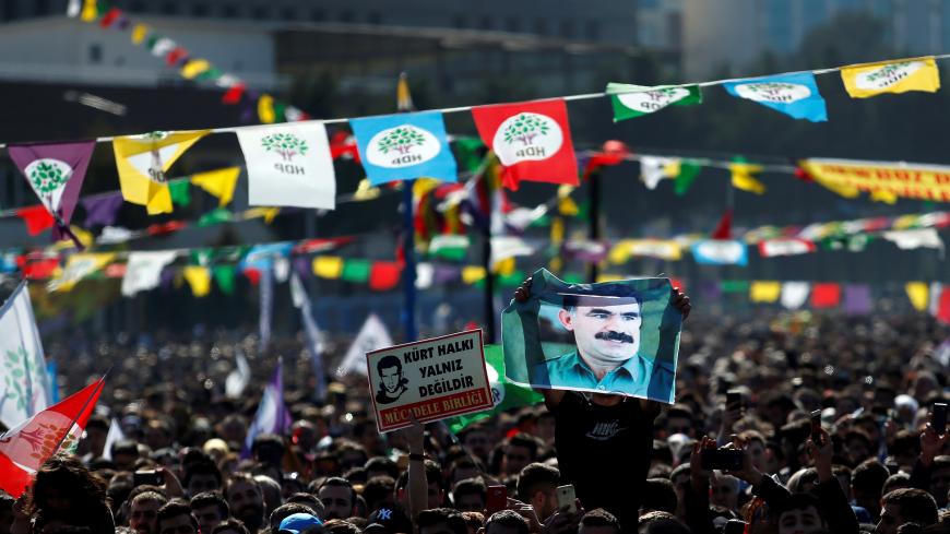 A man holds a picture of jailed Kurdistan Workers Party (PKK) leader Abdullah Ocalan as people gather to celebrate Newroz, which marks the arrival of spring and the new year, in Istanbul, Turkey March 24, 2019. REUTERS/Kemal Aslan - RC1291C94940