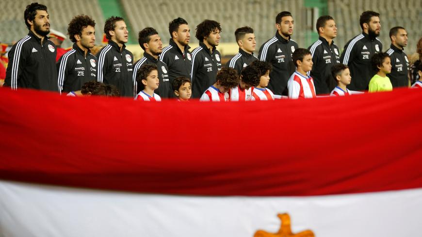Football Soccer - Egypt v Tunisia - International Friendly Match - Cairo Stadium, Egypt - 8/1/17- Team Egypt listens to the national anthem behind an Egyptian national flag ahead of the match. REUTERS/Amr Abdallah Dalsh - RC1D261A9970