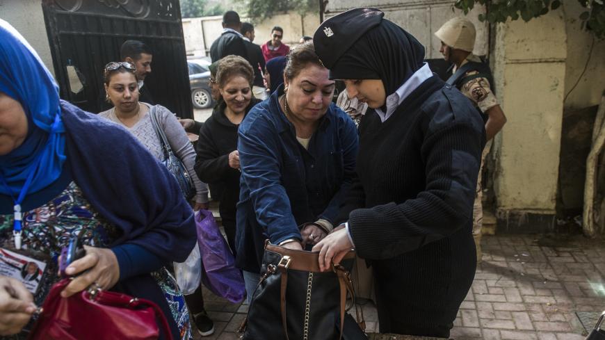 An Egyptian policewoman checks women's handbags outside a polling station in the capital Cairo on November 22, 2015, on the first day of the second and final round of the country's parliamentary elections. Egyptians began voting Sunday across 13 of the country's 27 provinces in the second phase of parliamentary elections after a low turnout marred the first stage in the absence of any strong opposition. AFP PHOTO / KHALED DESOUKI        (Photo credit should read KHALED DESOUKI/AFP/Getty Images)