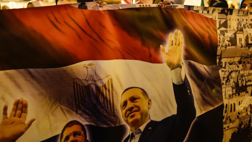Protesters hold a poster with Turkish President Recep Tayyip Erdogan and Egypt's former president Mohamed Morsi during a demonstration against the US and Israel at Fatih Mosque in Istanbul on December 6, 2017.  
Hundreds of people staged protests in Istanbul angrily denouncing the US president's move to recognise Jerusalem as the capital of Israel. / AFP PHOTO / YASIN AKGUL        (Photo credit should read YASIN AKGUL/AFP/Getty Images)