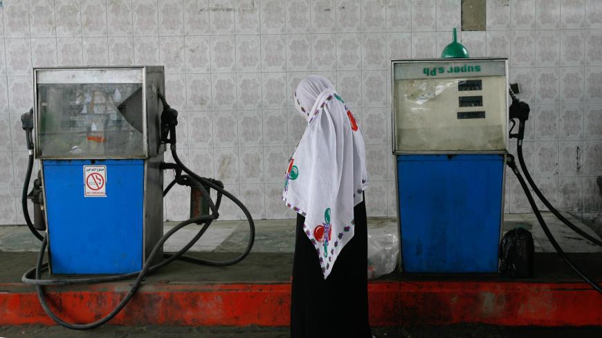JABALIYA, GAZA - MARCH 29: A Palestinian woman walks past a petrol pump at a fuel station on March 29, 2010 in Jabaliya, Gaza Strip. Fuel in Gaza is supplied primarily from the tunnels via Egypt, but is of poor quality. Nearly all goods for sale in Gaza have been smuggled from Egypt via smuggling tunnels, bringing in food, fuel, livestock, motorcycles and medicine. Gaza's economy and employment levels have plummeted since the Israelis imposed a blockade after Hamas seized control in 2007. (Photo by Warrick 