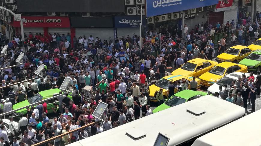 Iranian protesters gather at Mobile market in Tehran on June 25, 2018. - Protesters in Tehran shouted slogans and threw rocks in the streets on June 25, before being dispersed by anti-riot policemen. (Photo by ATTA KENARE / AFP)        (Photo credit should read ATTA KENARE/AFP/Getty Images)