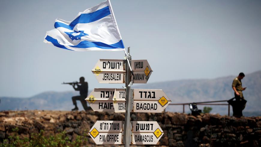 An Israeli soldier stands next to signs pointing out distances to different cities, on Mount Bental, an observation post in the Israeli-occupied Golan Heights that overlooks the Syrian side of the Quneitra crossing, Israel May 10, 2018. REUTERS/Ronen Zvulun     TPX IMAGES OF THE DAY - RC1D6EF6AF90