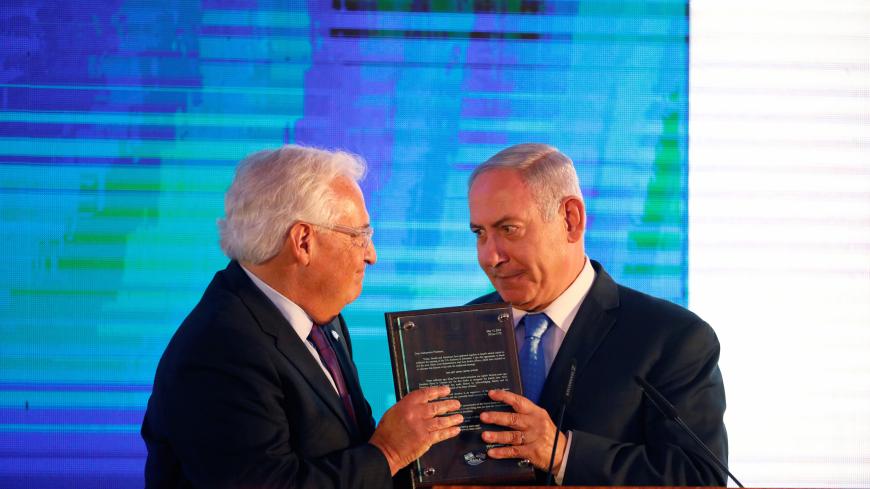 Israeli Prime Minister Benjamin Netanyahu hands U.S. Ambassador to Israel David Friedman a letter of appreciation, during a reception held at the Israeli Ministry of Foreign Affairs in Jerusalem, ahead of the moving of the U.S. embassy to Jerusalem, May 13, 2018. REUTERS/Amir Cohen - RC12C6659B00