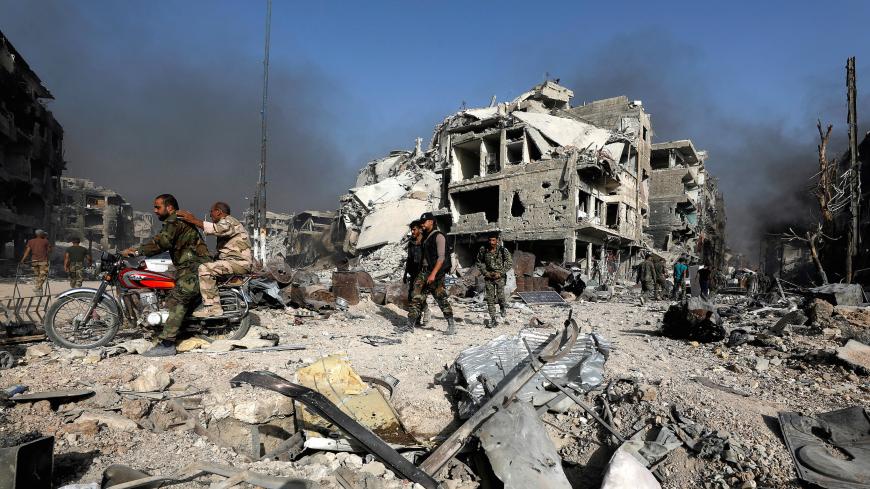 Syrian army soldiers ride on a motorbike at a damaged site in al-Hajar al-Aswad, Syria May 21, 2018. REUTERS/Omar Sanadiki     TPX IMAGES OF THE DAY - RC17435C2220
