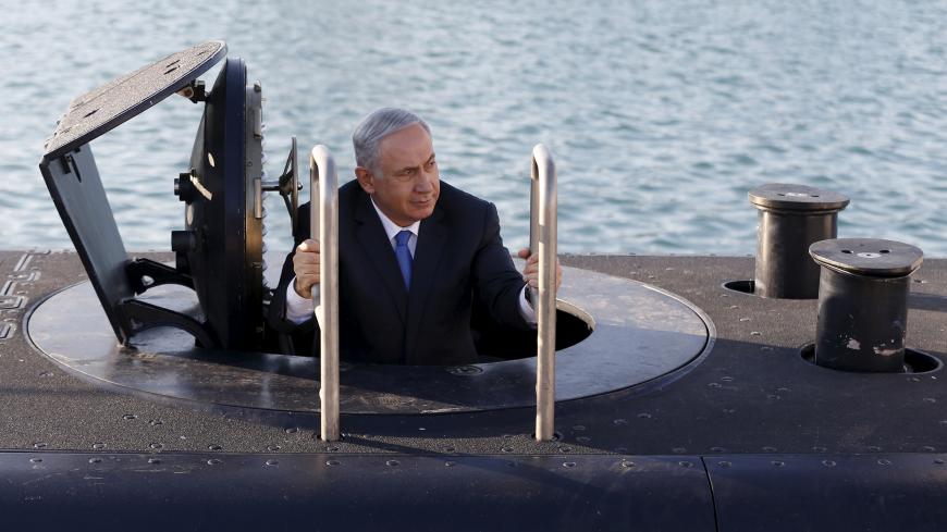 Israeli Prime Minister Benjamin Netanyahu climbs out after a visit inside the Rahav, the fifth submarine in the Israeli Navy's fleet, after it arrived in Haifa port January 12, 2016. The Dolphin-class submarines, widely believed to be capable of firing nuclear missiles, were manufactured in Germany and sold to Israel at deep discounts as part of Berlin's commitment to shoring up the security of the country set in part as a haven for Jews who survived the Holocaust.     REUTERS/Baz Ratner - GF20000092316