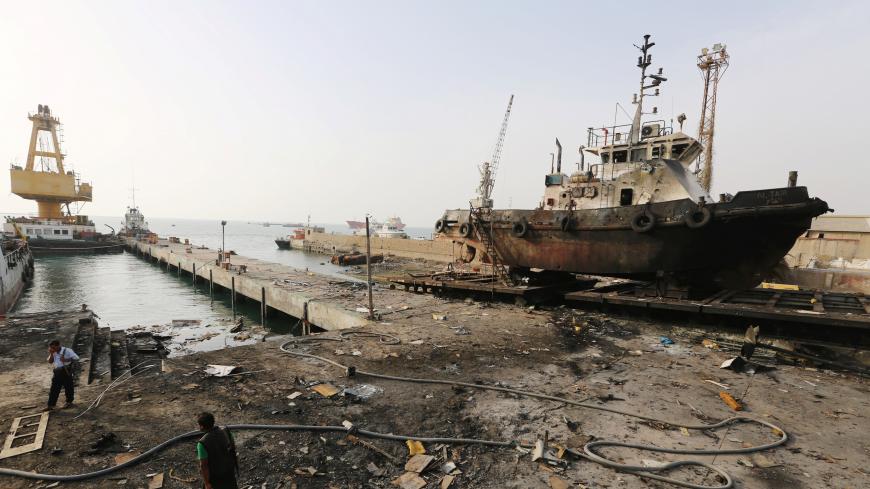 Workers inspect damage at the site of an air strike on the maintenance hub at the Hodeida port, Yemen May 27, 2018. REUTERS/Abduljabbar Zeyad - RC174C049830