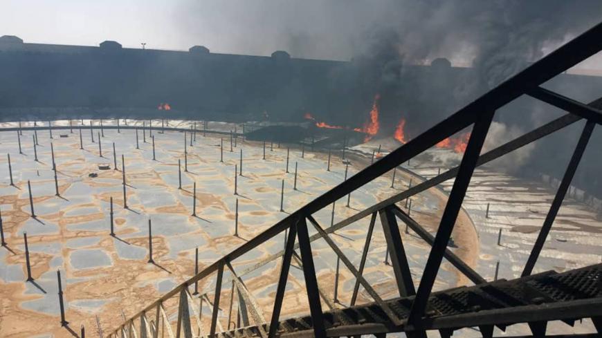 Smoke and flame rise from an oil storage tank that was set on fire amid fighting between rival factions at Ras Lanuf terminal, Libya in this handout picture released on June 16, 2018. The National Oil Corporation/ Handout via Reuters ATTENTION EDITORS - THIS PICTURE WAS PROVIDED BY A THIRD PARTY. REUTERS IS UNABLE TO INDEPENDENTLY VERIFY THIS IMAGE. - RC1597B41120