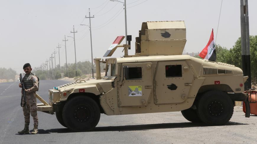 An Iraqi soldier stands next to a military vehicle at the entry of Zubair oilfield after a rocket struck the site of residential and operations headquarters of several oil companies at Burjesia area, in Basra, Iraq June 19, 2019.  REUTERS/Essam Al-Sudani - RC1B5B815400