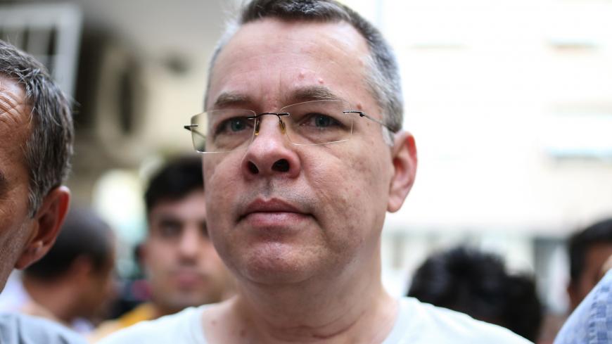 US pastor Andrew Craig Brunson escorted by Turkish plain clothes police officers arrives at his house on July 25, 2018 in Izmir. - Turkey on July 15, 2018 moved from jail to house arrest US pastor Andrew Brunson who has spent almost two years imprisoned on terror-related charges, in a controversial case that has ratcheted up tensions with the United States. Andrew Brunson, who ran a protestant church in the Aegean city of Izmir, was first detained in October 2016 and had remained in prison in Turkey ever si