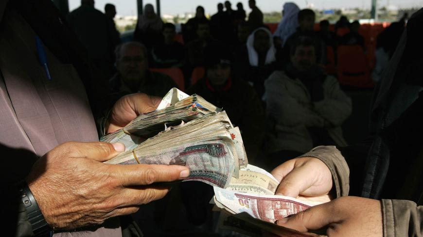 RAFAH, GAZA STRIP - NOVEMBER 23:  A Palestinian traveler exchanges money as he waits to leave the Gaza Strip for Egypt at the Rafah border crossing November 23, 2005 in the southern Gaza Strip. Palestinian officials now have control of the Rafah crossing for the first time in decades after U.S. Secretary of State Condoleezza Rice successfully brokered a deal on November 15. Palestinian President Mahmoud Abbas is expected to attend an official inauguration ceremony of the crossing on November 25.  (Photo by 
