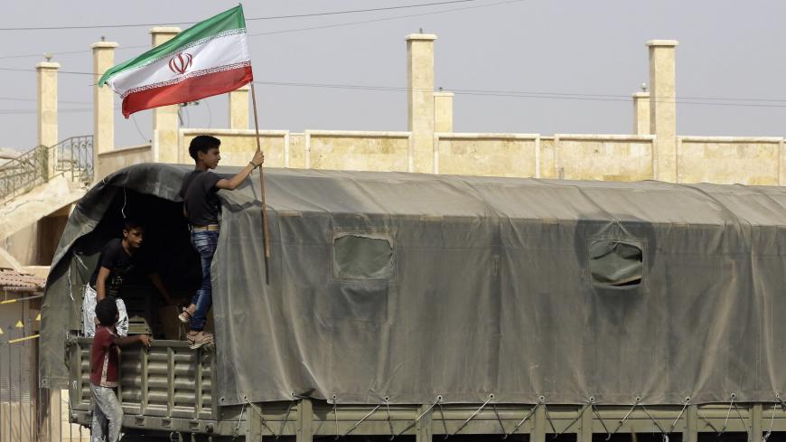 A Syrian boy holds the Iranian flag as a truck carrying aid provided by Iran arrives in the eastern city of Deir Ezzor on September 20, 2017 while Syrian government forces continue to press forward with Russian air cover in the offensive against Islamic State group jihadists across the province.
Two separate offensives are under way against the jihadists in the area -- one by the US-backed Syrian Democratic Forces, the other by Russian-backed government forces. The Syrian army now controls around 70 percent
