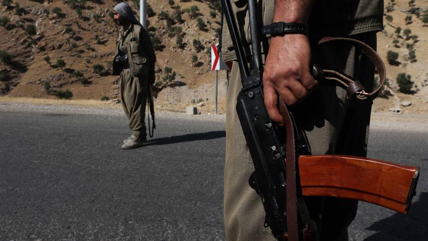 A member of the Kurdistan Workers' Party (PKK) carries an automatic rifle on a road in the Qandil Mountains, the PKK headquarters in northern Iraq, on June 22, 2018. - Hundreds of Iraqi Kurds marched Friday to protest Turkish strikes against the Kurdistan Workers' Party (PKK) after Turkey's President Recep Tayyip Erdogan said Ankara would press an operation against its bases. (Photo by SAFIN HAMED / AFP)        (Photo credit should read SAFIN HAMED/AFP/Getty Images)