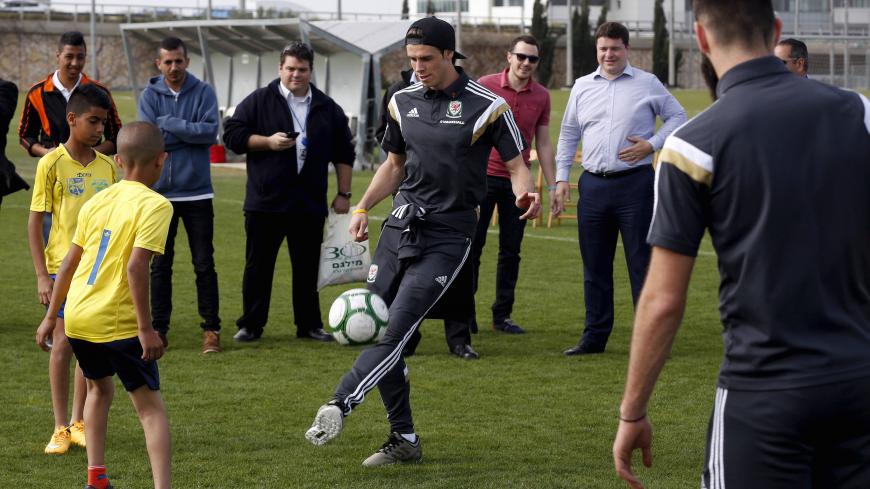Wales' Gareth Bale (C) takes part in a kick-about with Jewish and Arab children in the northern city of Haifa March 29, 2015. Bale forgot all about his recent troubles at Real Madrid when scoring twice in a superb Wales victory over Israel on Saturday that kept them on course for next year's Euro 2016 finals in France.     REUTERS/Baz Ratner - GF10000042594