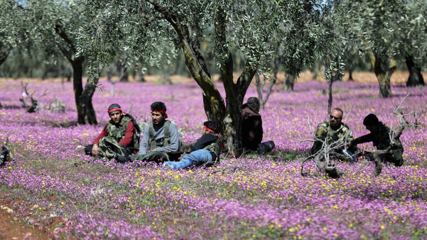 Turkish-backed Free Syrian Army fighters rest in a field in eastern Afrin, Syria March 9, 2018. REUTERS/Khalil Ashawi - RC1B3281C1A0