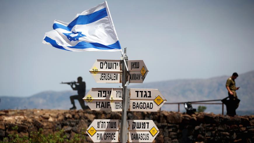 An Israeli soldier stands next to signs pointing out distances to different cities, on Mount Bental, an observation post in the Israeli-occupied Golan Heights that overlooks the Syrian side of the Quneitra crossing, Israel May 10, 2018. REUTERS/Ronen Zvulun     TPX IMAGES OF THE DAY - RC1D6EF6AF90