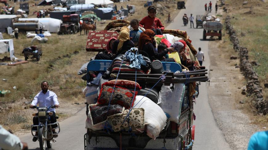 Internally displaced people from Deraa province sit on a truck loaded with belongings near the Israeli-occupied Golan Heights in Quneitra, Syria June 30, 2018. REUTERS/Alaa Al-Faqir - RC18ECA55210