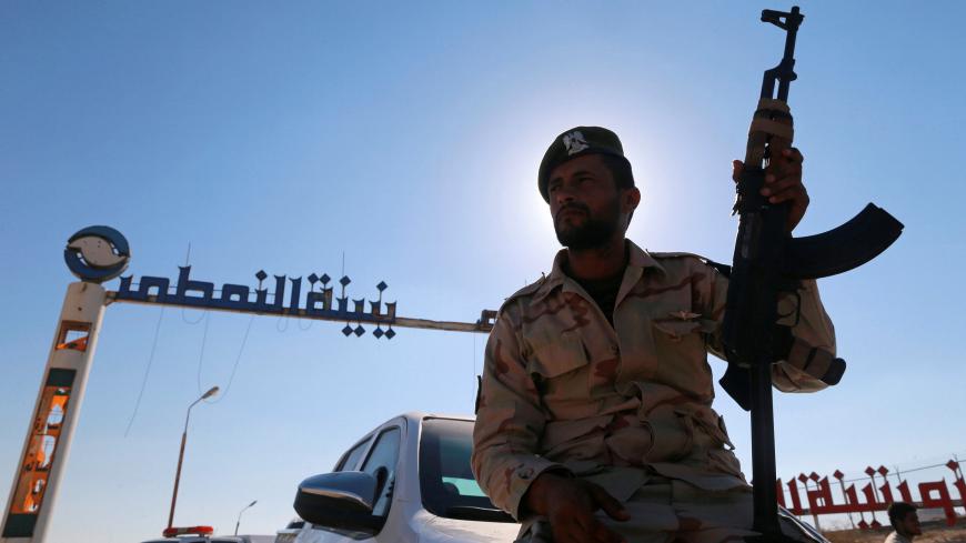A member of Libyan forces loyal to eastern commander Khalifa Haftar holds a weapon as he sits on a car in front of the gate at Zueitina oil terminal in Zueitina, west of Benghazi, Libya September 14, 2016. Picture taken September 14, 2016. REUTERS/Esam Omran Al-Fetori - D1BEUBKLFRAC