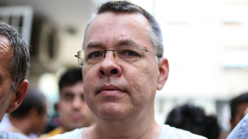 US pastor Andrew Craig Brunson escorted by Turkish plain clothes police officers arrives at his house on July 25, 2018 in Izmir. - Turkey on July 15, 2018 moved from jail to house arrest US pastor Andrew Brunson who has spent almost two years imprisoned on terror-related charges, in a controversial case that has ratcheted up tensions with the United States. Andrew Brunson, who ran a protestant church in the Aegean city of Izmir, was first detained in October 2016 and had remained in prison in Turkey ever si