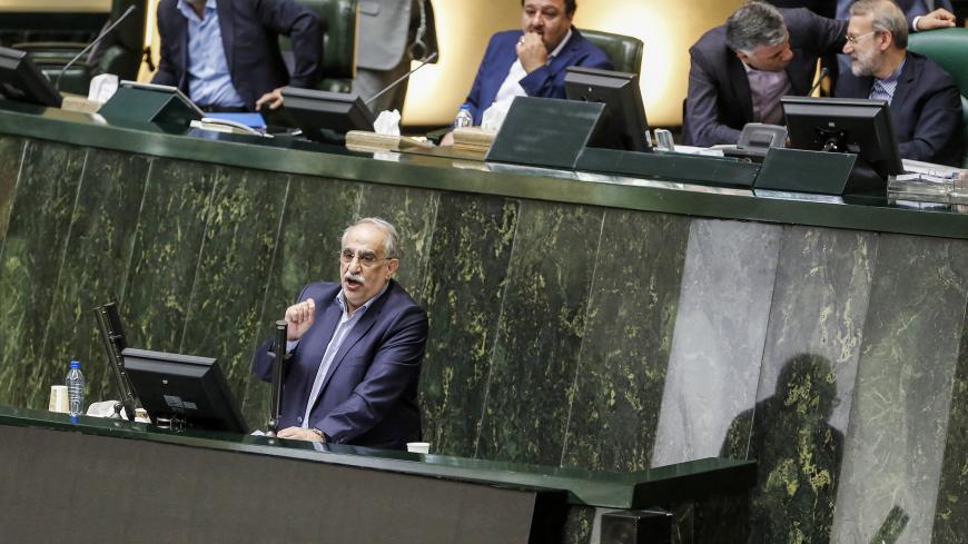 Masoud Karbasian (bottom), Iran's Economy Minister, speaks in parliament in the capital Tehran on August 26, 2018 before a vote by lawmakers which saw him impeached. - Karbasian is the second minister in President Hassan Rouhani's cabinet to be impeached this month, following the removal of Labour Minister Ali Rabiei on August 8. (Photo by ATTA KENARE / AFP)        (Photo credit should read ATTA KENARE/AFP/Getty Images)
