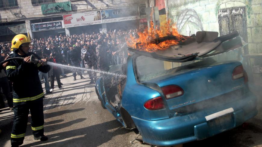A Palestinian firefighter douses a burning car during an earthquake drill organised by the civil defence forces in the West Bank city of Jenin on February 16, 2012. AFP PHOTO/SAIF DAHLAH (Photo credit should read SAIF DAHLAH/AFP/Getty Images)