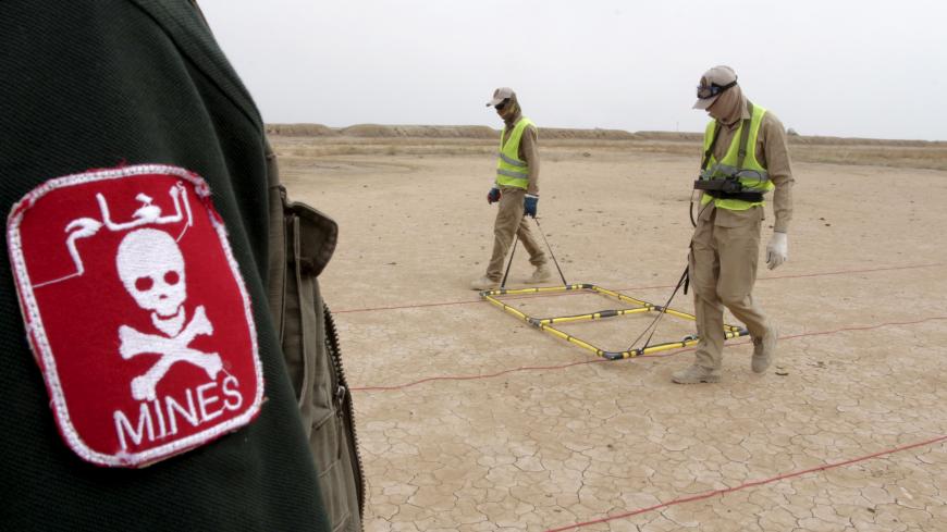 De-mining teams searches for landmines in the desert east of Basra province, April 1, 2015. In Iraq's vast southern desert, de-mining teams are working to remove millions of Saddam-era landmines and explosive ordnance that litter Iraq's southern giant oil fields, hampering the country's oil boom and delaying investment. Picture taken April 1 2015.  REUTERS/Essam Al-Sudani  - GF10000051566