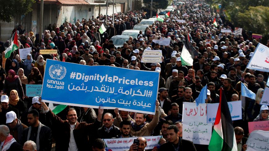 Palestinian employee of United Nations Relief and Works Agency (UNRWA) hold a sign during a protest against a U.S. decision to cut aid, in Gaza City January 29, 2018. REUTERS/Mohammed Salem - RC1CCE65B060