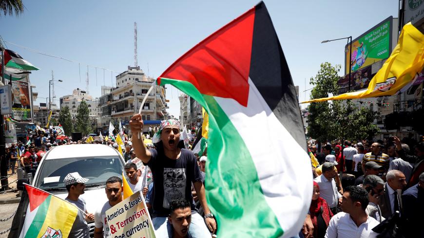 A man holding a Palestinian flag shouts slogans during a rally in support of President Mahmoud Abbas, in Ramallah, in the occupied West Bank, July 2, 2018.  REUTERS/Mohamad Torokman - RC13D0F03040