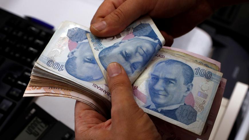 A money changer counts Turkish lira banknotes at a currency exchange office in Istanbul, Turkey August 2, 2018. Picture taken August 2, 2018. REUTERS/Murad Sezer - RC1308E57BC0