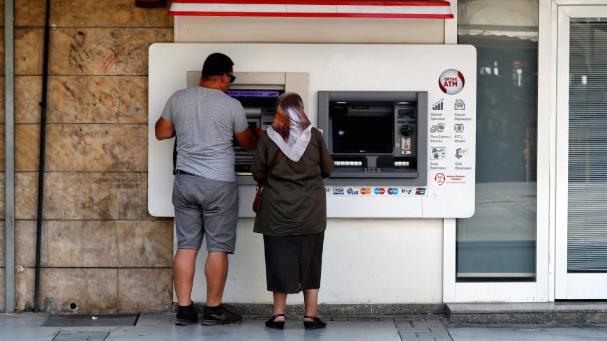 People withdraw money from a bank ATM in Izmir, Turkey August 18, 2018. REUTERS/Osman Orsal - RC1CDE255B70