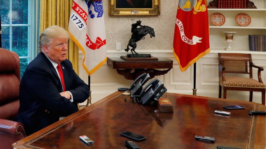U.S. President Donald Trump answers a reporter's question as eight different phones and recording devices placed on his desk by reporters and White House staff members record his words during an interview with Reuters in the Oval Office of the White House in Washington, U.S. August 20, 2018.  REUTERS/Leah Millis TPX IMAGES OF THE DAY - RC1CEA11EEE0