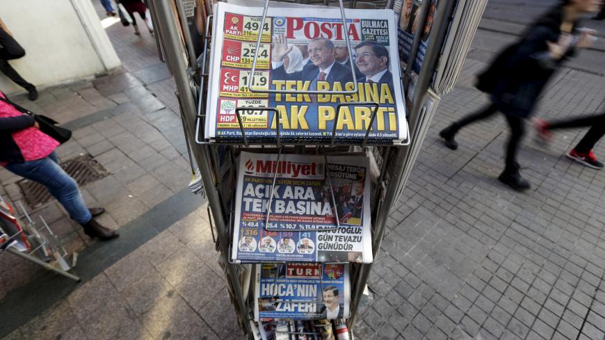 People walk past by a kiosk in central Istanbul, Turkey November 2, 2015. A jubilant President Tayyip Erdogan on Monday cast the return of Turkey's Islamist-rooted AK Party to single-party rule as a vote for stability that the world must respect, but opponents fear it heralds growing authoritarianism and deeper polarisation. The newspaper headline on top reads: "AK Party on its own" REUTERS/Murad Sezer  - GF20000042993
