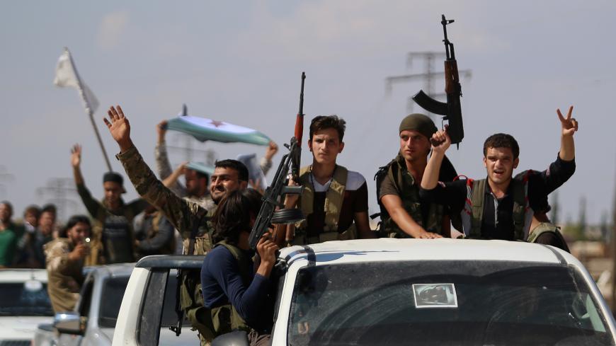 Syrian rebel fighters from the recently-formed "National Liberation Front" parade following military training at an unknown location in the northern countryside of the Idlib province on September 11, 2018, in anticipation for an upcoming government forces offensive. - The Syrian regime and its Russian ally are threatening an offensive to retake the northwestern province of Idlib, Syria's last rebel bastion. (Photo by Aaref WATAD / AFP)        (Photo credit should read AAREF WATAD/AFP/Getty Images)