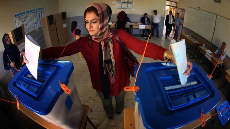 An Iraqi woman casts her vote in Iraq's parliamentary election (ballot-L) and in a postponed Kurdish regional election (ballot-R) in Arbil, the capital of the autonomous Kurdish region of northern Iraq, on April 30, 2014. Iraqis streamed to voting centres nationwide, amid the worst bloodshed in years, as Prime Minister Nuri al-Maliki seeks reelection. AFP PHOTO / SAFIN HAMED        (Photo credit should read SAFIN HAMED/AFP/Getty Images)
