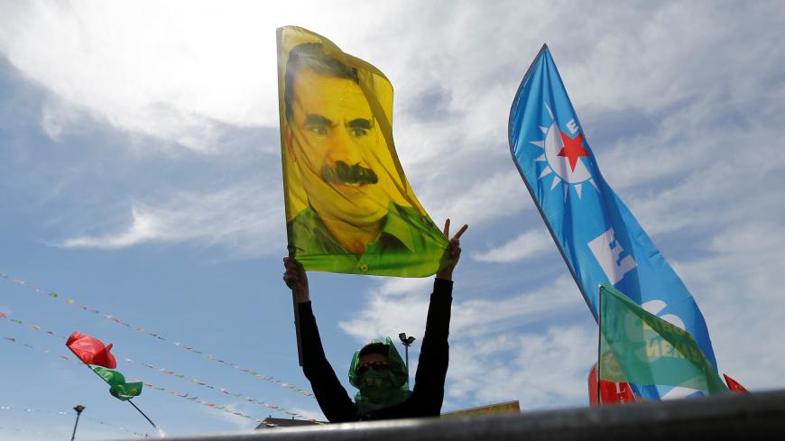 A man holds a flag with a picture of imprisoned Kurdish rebel leader Abdullah Ocalan during a gathering to celebrate Newroz, which marks the arrival of spring and the new year, in Istanbul, Turkey March 21, 2018. REUTERS/Murad Sezer - RC1FB1A51280