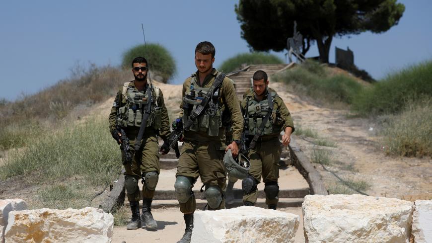 Israeli soldiers walk next to the southern city of Sderot on the Israeli side of the Israel - Gaza border, Israel August 9, 2018. REUTERS/Amir Cohen - RC132BF1AE50